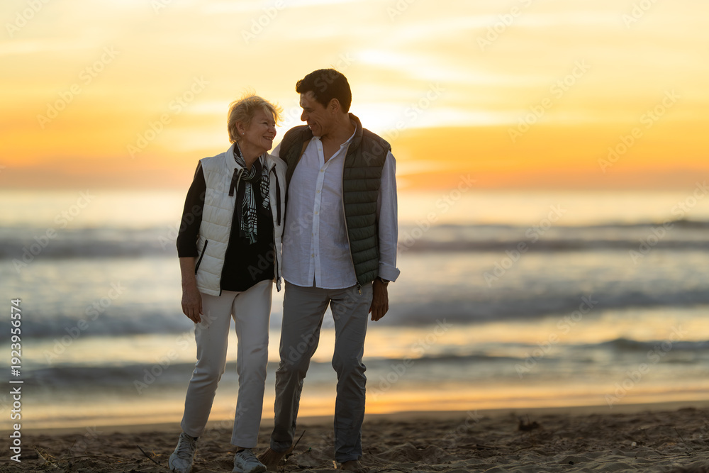 Fototapeta premium Mother and son walking on beach enjoying sunset