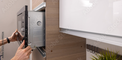 integrated microwave oven installation in the domestic kitchen. household appliance service. copy space