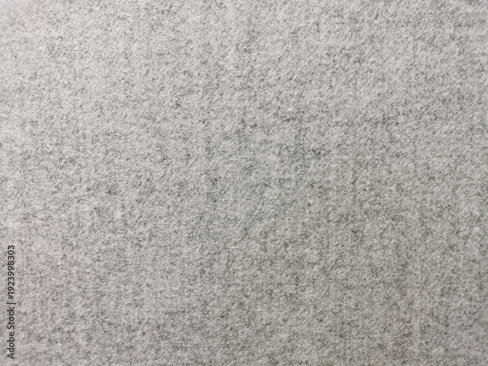 Fototapeta premium High-quality close-up of a seamless grey felt texture with a soft, heathered finish. The dense, non-woven fibrous surface creates a clean, neutral background perfect for minimalist design, industrial