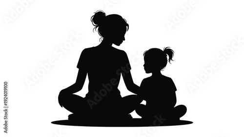 Mother and child meditating together in yoga poses on the floor in silhouette