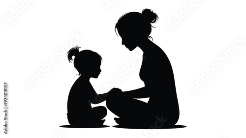 Mother and child sitting together in silhouette holding hands in a tender moment of love and connection
