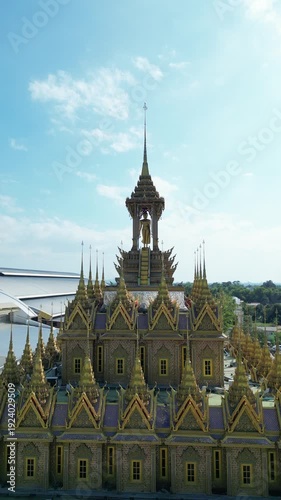 Thai Temple Architecture Aerial View with Ornate Golden Spires and Courtyard Under Blue Sky