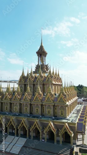 Thai Temple Architecture Aerial View with Ornate Golden Spires and Courtyard Under Blue Sky