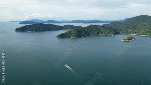 Wallpaper Mural Boat is sailing in the ocean near a mountain at Pulau Pangkor. The sky is cloudy and the water is calm Torontodigital.ca
