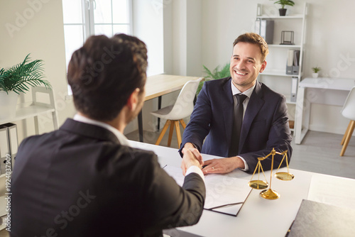 Foto Professional lawyer makes hand shake gesture with client as culmination of their agreement, pose at office desk, have successful deal