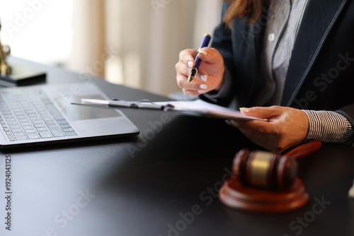 Canvastavla Female lawyer reviewing and signing a legal document while working on a case in her office