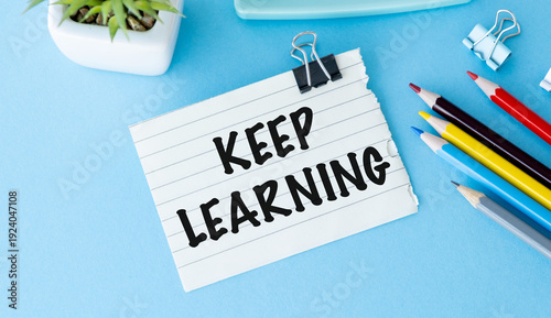Keep Learning motivational quote on paper note at office desk