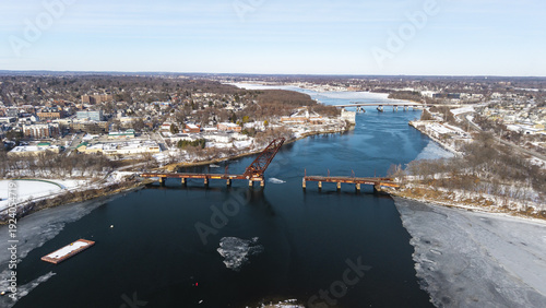 Aerial view of the Seekonk River with the open Crook Point Bascule Bridge cutting through the icy waters under a clear blue sky, Providence, Rhode Island, United States.