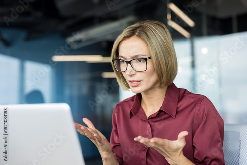 Obraz na płótnie Angry businesswoman in glasses working on laptop, experiencing stress and confus