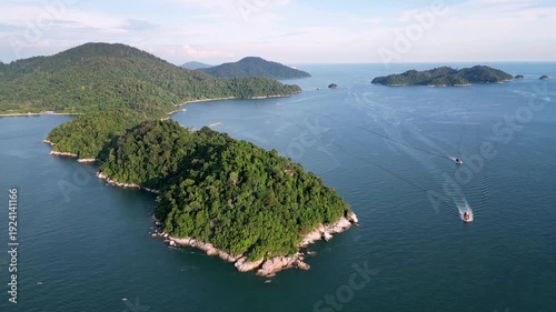 Aerial shot highlights Pulau Pangkor forested hills, dense greenery contrasting with bright beaches and clear sea.