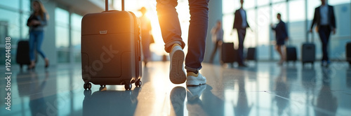 Business travelers walking through airport terminal with luggage during sunset, showcasing modern design elements in busy travel environment.