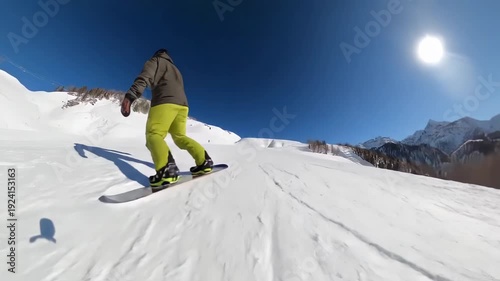 Snowboarder Racing Down Snowy Mountains Under Bright Blue Sky