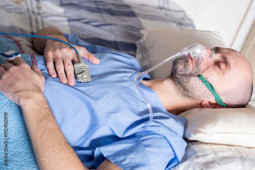 male patient in bed with oxygen mask, Human-centered health support, respiratory support, clinical ventilation interface obstructive sleep apnea treatment, medical breathing equipment in hospital