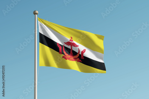 Brunei national flag waving on pole against clear blue sky background.