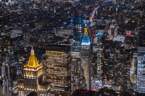 Night aerial view of Manhattan cityscape with illuminated skyscrapers and historic Flatiron District architecture in New York City USA