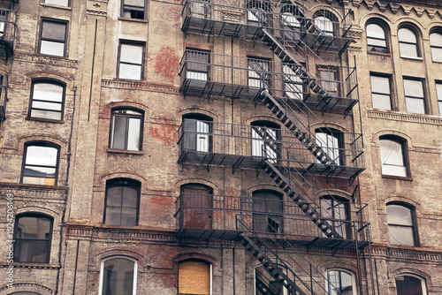 Rusty fire escapes on an old brick building. Edited as a vintage photo. Horizontally. 