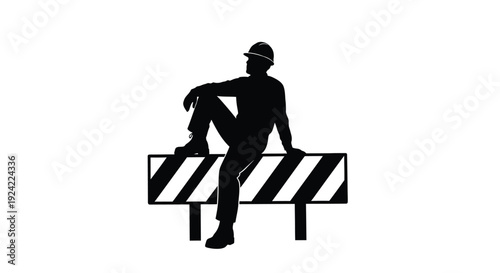 Silhouette of a worker resting on construction barrier