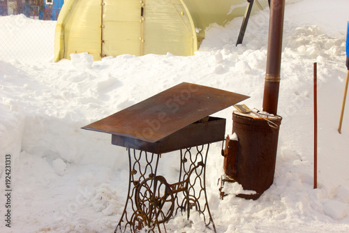 Мангал накрыт листом железа.The grill is covered with a sheet of iron.