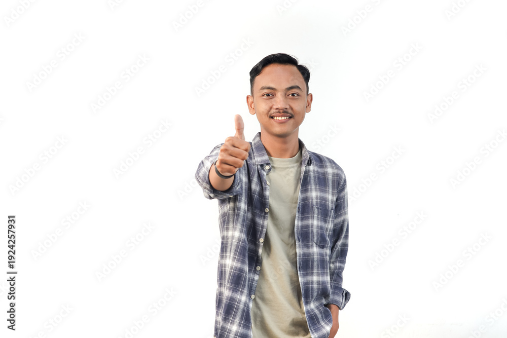 Fototapeta premium Asian man wearing a plaid shirt with a thumbs up expression is posing on an isolated white background.