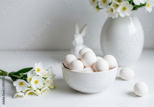 Easter eggs in bowl with flowers and bunny on white background