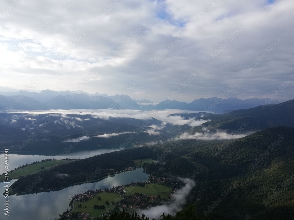 Fototapeta premium See in den Bergen im Nebel von oben
