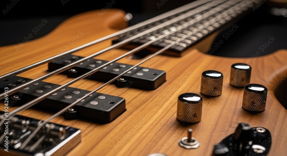 Fototapeta premium Close up of a wooden bass guitar with strings and control knobs