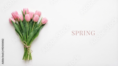 Bundle of pink tulips tied with twine on white surface. Top view flat lay of fresh spring flowers. Seasonal concept for womens day valentine and spring greetings