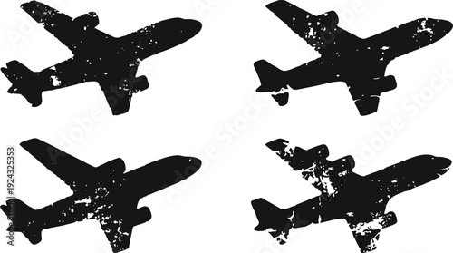four black airplane silhouettes with distressed texture in various flight angles on white background