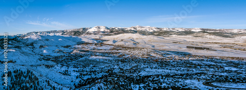 Aerial view of Mt. Rose, Nevada, USA, showcasing a snow-covered mountainous landscape. The peaks, part of the Sierra Nevada range, are accentuated by a clear blue sky. 