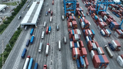 Busy container terminal with trucks and cargo ships