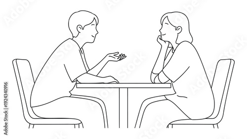 Two people are seated at a table engaged in conversation