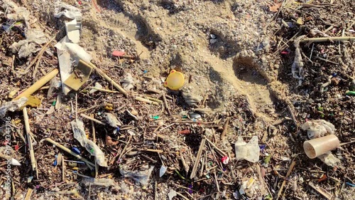 Beach with debris after the storm.
Close-up of the beach sand with waste material thrown by the sea onto the shore.