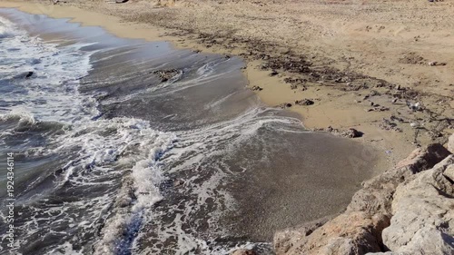 Beach with waste after the storm. 
View of the beach with marine debris washed ashore by the waves.