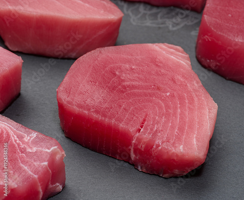 Raw tuna pieces on a black board, snack