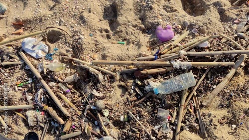 Beach with debris after the storm.
Close-up of the beach sand with waste material thrown by the sea onto the shore.