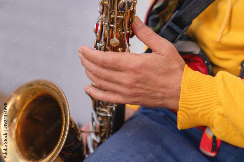 Obraz premium Musician plays saxophone on street during afternoon session in city