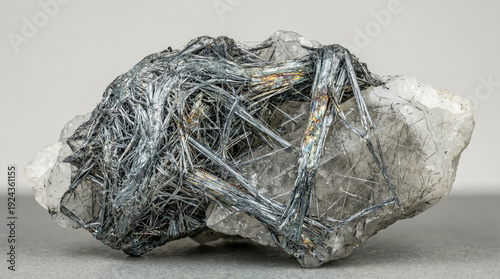 Tangled acicular aggregate of dark grey jamesonite crystals in white quartz matrix.