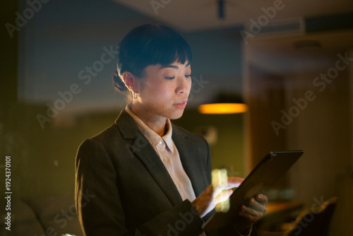 Asian businesswoman working late with digital tablet in office