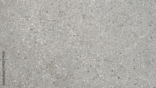 Light gray terrazzo concrete surface with small white and dark stone chips, flat lay texture background.