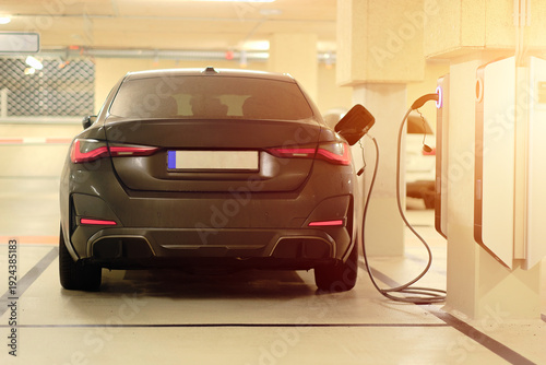 Rear View Of Plug-In Hybrid Electric Vehicle Charging at EV Station in Underground Parking