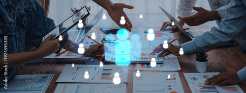 Obraz na plátne A diverse team engages in a collaborative business meeting, analyzing data and sharing ideas, with digital user icons overlaying a modern workspace