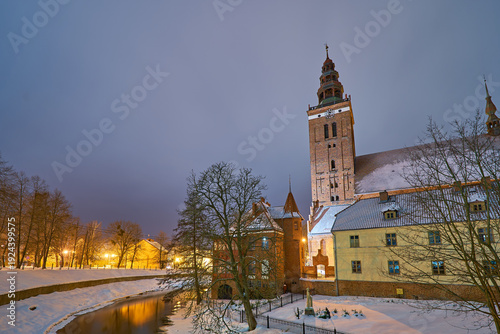 Lidzbark Warminski, Poland - february 17, 2026 - Gothic church tower illuminated at twilight in winter