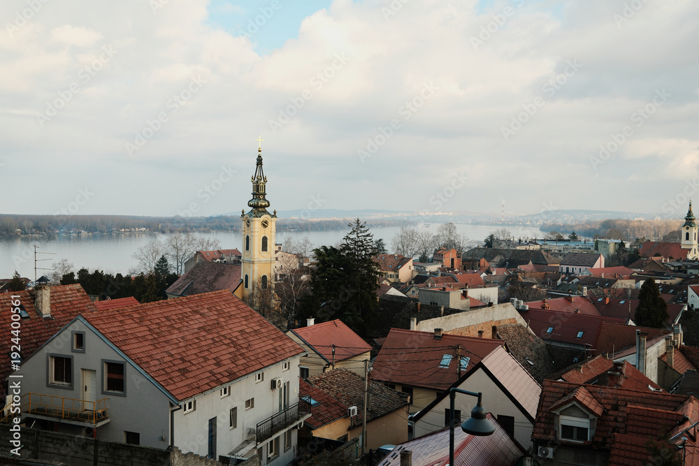 Fototapeta premium View from Gardos Tower over Danube River and Zemun old town with church tower and red roofs, capturing waterfront scenery and historic charm.