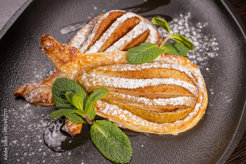 Dessert of fried pear sprinkled with powdered sugar
