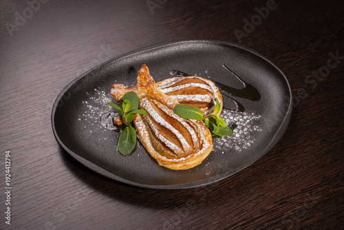 Dessert of fried pear sprinkled with powdered sugar