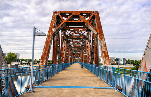 Εκτύπωση καμβά Pedestrian walkway on the rusty steel truss Junction Bridge over the Arkansas River, with the USS Razorback submarine visible in Little Rock, Arkansas, United States