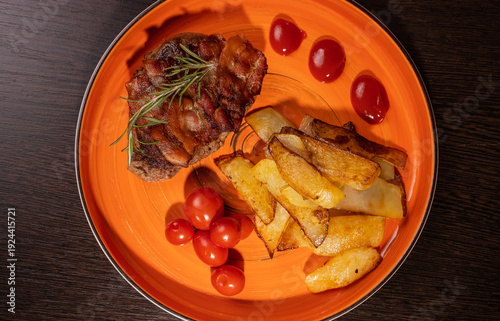 Steak with fried potatoes and tomatoes on a plate