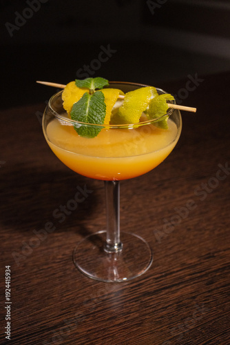A alcoholic cocktail with orange juice is beautifully decorated by the bartender