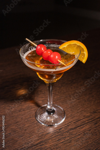 A champagne cocktail in a beautiful glass with pickled berries on a skewer