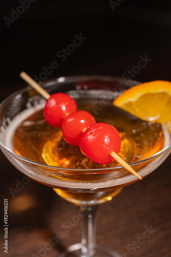 A champagne cocktail in a beautiful glass with pickled berries on a skewer